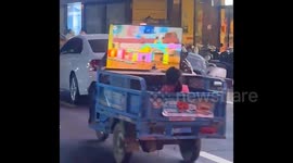 Electric three-wheeler fitted with LCD screen for young passenger's entertainment in China