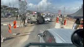 Car pushed off road by Israeli military vehicle at checkpoint in West Bank