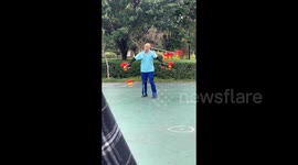 Elderly Chinese man simultaneously juggles six diabolos in Chinese park