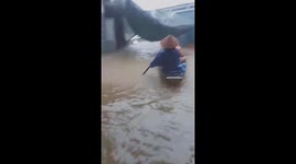 Desperate scenes as dozens of Vietnamese workers trapped at construction site by floods are rescued by boats