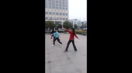 Fitness enthusiasts use badminton rackets while performing Tai Chi routine