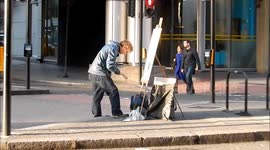 Painter Paints artwork In The Middle Of Traffic Island in Holborn