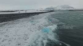 Beautiful footage of waves crashing into small icebergs in a glacier lagoon