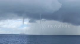 Creepy double waterspout tornado forms near ship's path
