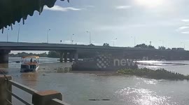 Loose cement carrier hits bridge pier while drifting along fast-flowing river in Thailand