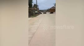 Large wooden house overloads back of twice smaller pickup truck