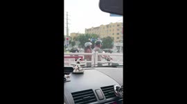 Couple bounce on e-bike while waiting at traffic lights in China
