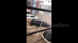 Motorcyclist desperately fights flood as vehicles swept down the street in Santo Domingo, Dominican Republic