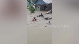 Brave villagers rescue neighbour stranded in flood as record rainfall batters Philippines town