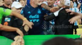 Players watch on as violent clashes erupt between Argentinian fans and police erupt