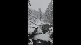 Mesmerizing winter scene as river flows amidst heavy snowfall in Byron, Maine
