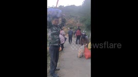 Villagers scramble for scattered oranges after truck tumbles down slope in China
