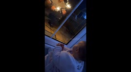 Cute baby is captivated by the enchanting fireworks display in the garden