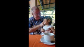 A little girl breaks out into contagious laughter at breakfast table