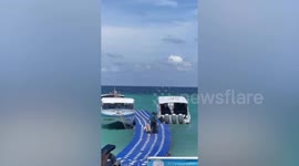 Tourists battle to stay upright on wobbly pontoon bridge to reach boats