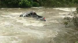 Locals pull pickup truck caught in surging flash flood in Thailand