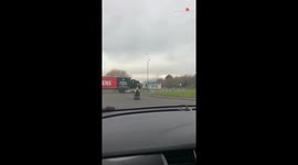 Carefree elderly gentleman zooms around a roundabout on his mobility scooter