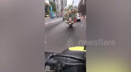 Overloaded motorcycle with vegetables ride around Bangkok
