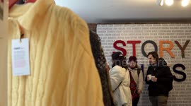 Shoppers browse Save The Children second-hand Christmas jumper pop-up in London, UK