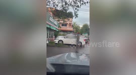 Furious street vendor attacks parked sedan with traffic cone
