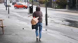UK Weather, Shoppers brave winter weather and struggle to close their car door against the gale. Newquay Cornwall UK