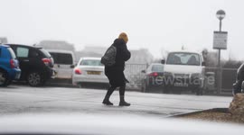 UK Weather, Strangers help others as people struggle in ferocious winds whilst shopping Newquay Cornwall UK.