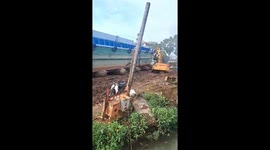 The excavator driver controls the excavator to help the giant ship safely launch into the river