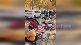 Residents take foot baths on flooded road amid rain in China