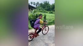 Schoolboy rides cool bicycle with car steering wheel attached
