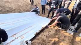 Palestinians bury dead bodies of Palestinian families in a mass grave on Dair El-Balah central of Gaza Strip. The Families lost their lives during the attacks of Israel.