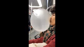 Chinese man stuns commuters with enormous bubble gum blow