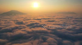 Stunning time-lapse reveals sun rising above clouds rolling like ocean waves
