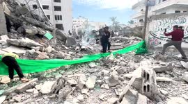 Palestinians inspect the wreckage following an Israeli air strike on the Jaffa Mosque in Dair El-Balah,