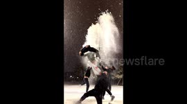 Young acrobats execute high-difficulty backflips in snowy weather