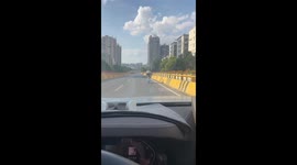 Motorcycle rider does yoga pose while cruising along motorway