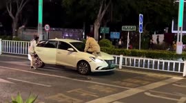 Chinese man leaps onto car hood to retrieve girlfriend's lost phone