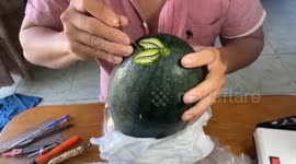 A Vietnamese chef sculpts a rose with many delicate and beautiful patterns onto a watermelon