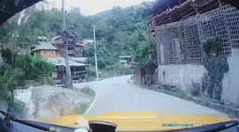 Motorcycle crashes into oncoming car down sloped road curve