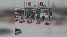 Drive slams into highway toll station on ice-covered road in China