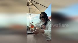 Woman saves cocktail when she knocks it over with elbow