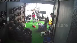 Pickup truck crashes into repair shop and hits pile of tires
