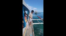 Tourist leaps from boat but accidentally hits his face on rope