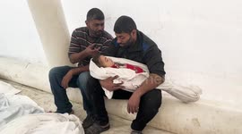 Palestinians pray during the funeral of their relatives, who were killed after an Israeli airstrike on the city of Dair El-Balah, at Al-Aqsa Hospital