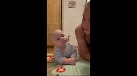 Captivating connection: mother and infant lock eyes in heartwarming tummy time moment