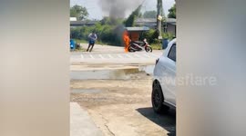 Street vendor tries to put out fire from burning motorcycle meatball cart