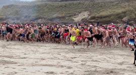 1000 crazy English swimmers go swimming in the Atlantic Ocean in the rain to Celebrate Christmas Day from Sennen Cove , Cornwall England #ChristmasSwim