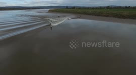 Aerial of kayakers and surfers riding today's Severn bore