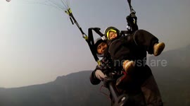 Two-year-old boy goes tandem paragliding with his dad
