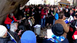 People sing Christmas carols under the Charles Bridge in Prague, Czechia