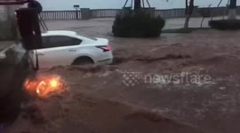Cars drive through flash floods during storm in China